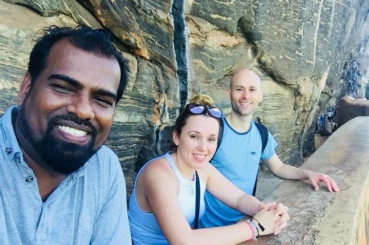 Guests and their tour host beside a stone walkway