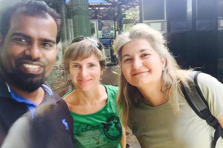 Two guests and their tour host outside a building